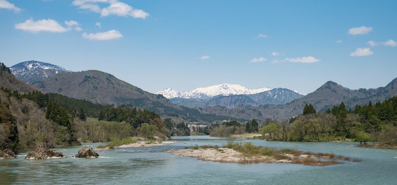 阿賀町鹿瀬から阿賀野川と遠景は飯豊連峰大日岳方面
